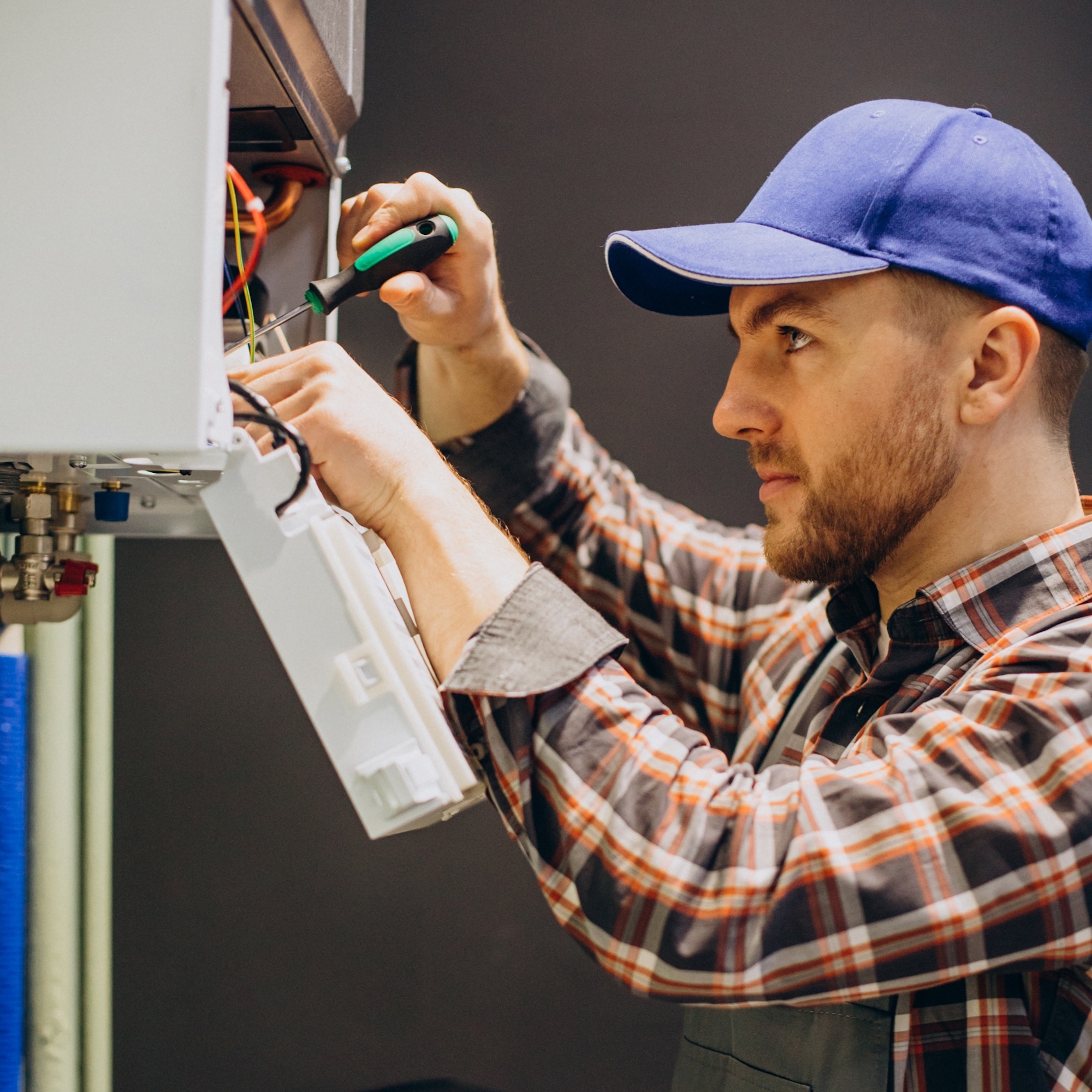 service-man-adjusting-house-heating-system@2x