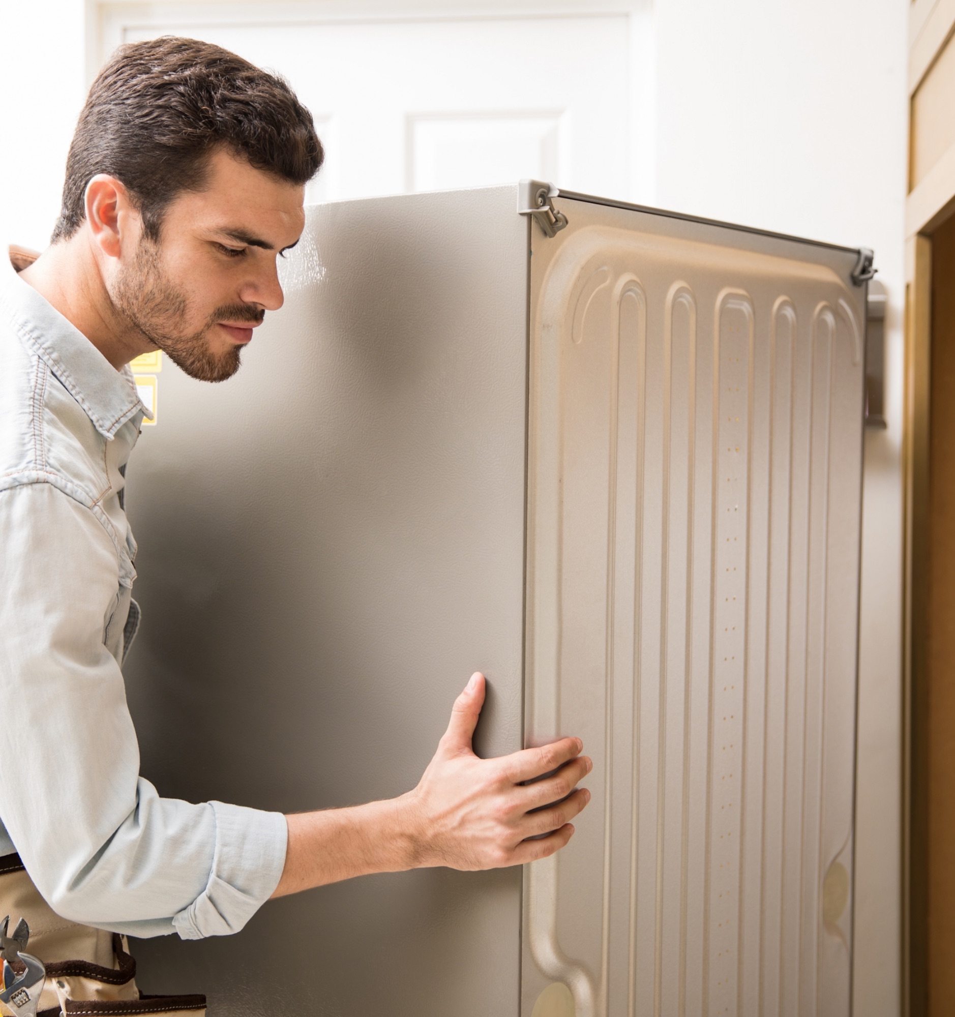 young-man-working-as-electrician-exposing-back-fridge-check-repair-it@2x
